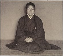 Portrait of a boy priest, seated and facing the camera