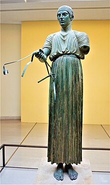 Charioteer of Delphi wearing a chiton. Charioteer of Delphi - Delphi Archaeological Museum by Joy of Museums.jpg