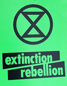Extinction Rebellion placard containing its logotype with the extinction symbol Extinction Rebellion, green placard (cropped).jpg