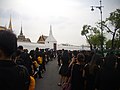 Kø af sørgende med gule blomsterguirlander foran Grand Palace på årsdagen for kong Rama IXs død (13. oktober, 2017)