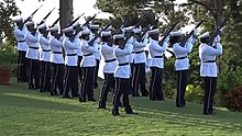 The Royal Saint Lucia Police Force fire a 96-gun salute at Government House, Castries, following the death of Elizabeth II, Queen of Saint Lucia Ninety-six gun salute in Saint Lucia following the Queen's passing.jpg