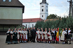 The inhabitants in traditional customes with the church tower in the background