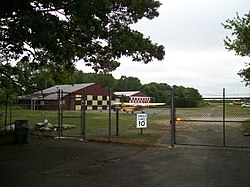 Bayport Aerodrome;
Hangaro malantaŭ Fence.JPG