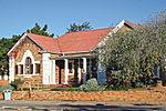 Single storey stone Arts & Crafts style building with white plaster decoration to windows and corners. Doric columns to porch between two forward facing wings with triangular barge-boarded gable. Architectural style: Arts & crafts. Type of site: Library. Current use: Library.