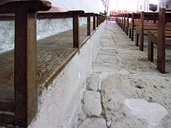 Banquette en pierre le long du mur de la nef.