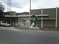 La entrada principal al estadio Municipal con una obra artística que honra virtudes deportivas.