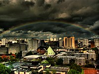 Wolke en 'n reënboog oor die middestad van Glasgow.