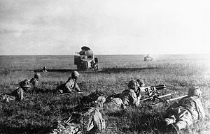Японские солдаты ползут к подбитым советским танкам.
