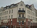 Mietshaus in geschlossener Bebauung in Ecklage, mit Vorgarten und Pflaster vor dem Hauseingang