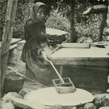 A Norwegian peasant making flatbread in the 1910s. Norwegian peasant baking bread.png