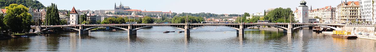 Panoramatický pohled na Jiráskův most, za ním vlevo Malostranská vodárenská věž, vpravo od ní Dětský ostrov, uprostřed Střelecký ostrov, vpravo pak Slovanský ostrov, v pozadí panoráma Hradčan