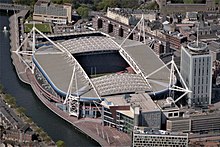 Exterior view of a stadium from across a river