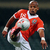 A footballer attempts to control a ball