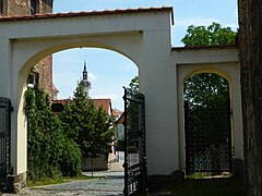 Tor des Ritterguts, im Hintergrund die Stadtkirche