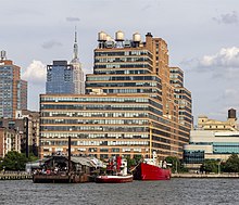 The Starrett–Lehigh Building as seen from the Hudson River. A red boat is docked at a pier in the foreground.