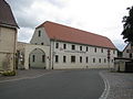 Wohnstallhaus (Nr. 1), Torbogen (mit zwei Prellsteinen) und Seitengebäude (Nr. 1a) eines ehemaligen Vierseithofes