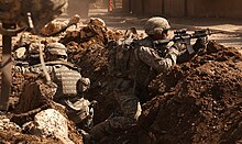 US soldiers take cover during a firefight with insurgents in the Al Doura section of Baghdad, 7 March 2007. Army.mil-2007-03-21-084518.jpg