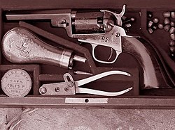 Um Colt Pocket 1849 sem alavanca de recarregamento com acessórios