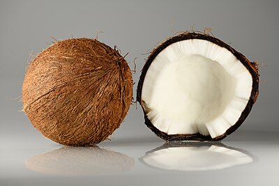 Ryp kokosneute (Cocos nucifera), in sy dop en oopgebars. Gekweek in die Dominikaanse Republiek.