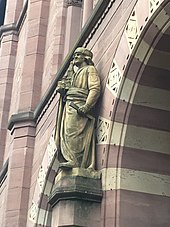 Statue von Erwin von Steinbach mit einem Architektur-Modell in der rechten und einem Zimmermannswinkel in der linken Hand.