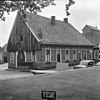 Gebouwtje van baksteen op Bentheimer stenen plint, met houten topgevel en halfrond beëindigde houten inrijpoort