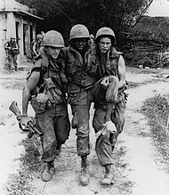 A wounded African-American soldier being carried away, 1968 Haeberlewounded.jpg