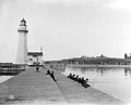 Recreational fishing at Pierhead Light in Oswego, New York, c. 1900. Fort Ontario behind.