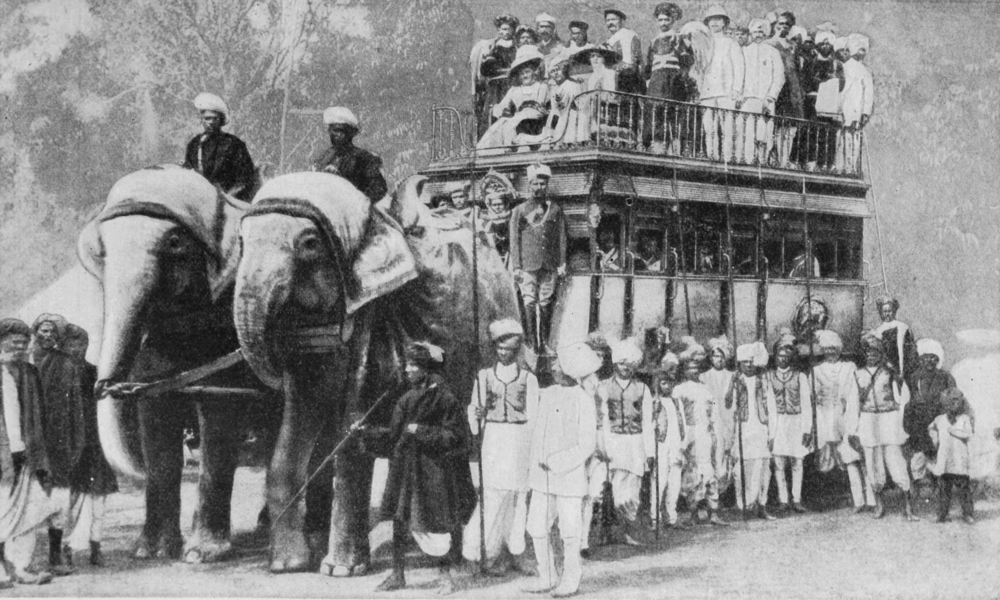 image of weeding guests in a omnibus-like vehilcle with elephants in front