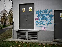 Graffiti in Poznan, Poland: "Boy-girl is the normal family". This has, in turn, been graffitied to add the word "not" in Polish, and two female symbols. Park Kosynierow in Poznan (chlopak dziewczyna normalna rodzina).jpg