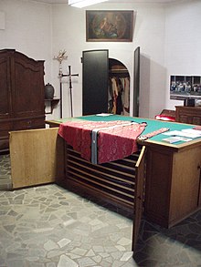 Sacristy with a sacristy credens (a cabinet with wide and very shallow drawers in which vestments and hangings are stored). A chasuble and stole are laid out on top of it, ready to be put on. Sacristygennep.jpg