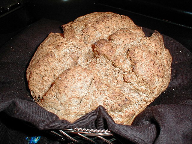 round bread loaf with craggy brown surface marked with an x