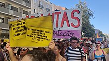 Grupo de protestantes com faixas e cartazes a reivindicar habitação justa e sustentável.