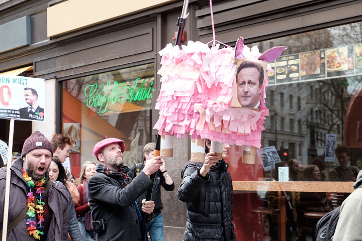 Um manifestante segurando uma piñata em forma de porco na parte inferior da Kingsway. Imagem: Tom Morris.