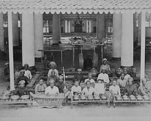 large group of musicians in Javanese costume, with percussion instruments