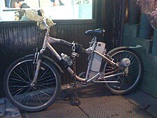Motorized delivery bike for a restaurant, with chain, lock, and plastic bags on handles to protect from winter wind Delivery bike NYC.jpg