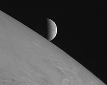 Jupiter occupe la partie gauche et basse de l'image, apparaissant grisâtre. Europe, au centre de l'image, apparaît en croissant.