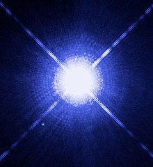 Sur fond bleu sombre, Sirius A, au centre, est très grande. En comparaison, Sirius B est toute petite.