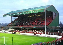 Green-covered grandstand, with advertising on top