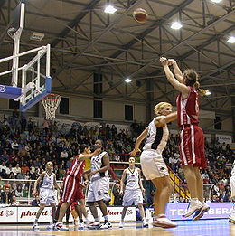 Een basketballer maakt een driepunter.