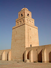 Квадратная каменная башня возвышается над стеной.