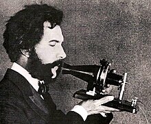 Bell's first telephone transmitter, ca. 1876, reenacted 50 years later Actor portraying Alexander Graham Bell in an AT&T promotional film (1926).jpg