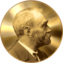 A golden medallion with an embossed image of a bearded man facing left in profile. To the left of the man is the text "ALFR•" then "NOBEL", and on the right, the text (smaller) "NAT•" then "MDCCCXXXIII" above, followed by (smaller) "OB•" then "MDCCCXCVI" below.