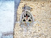 Photographie montrant un mur conservé de l'ancienne abbaye, avec sa fenêtre gothique.