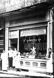 Jean Larrieu et sa famille posant devant sa charcuterie située 25 rue Léon-Gambetta.