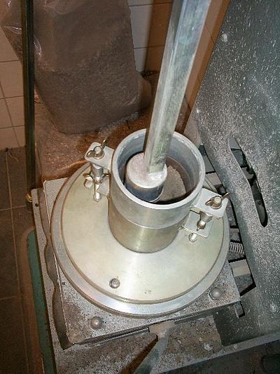 Een machine met een gewicht van 2,5 kg met een oppervlakte van 50,8 mm slaat met 25 slagen per laag het monster aan.