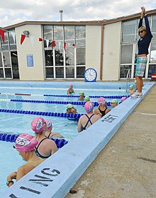 Karlyn Pipes, right, teaches service members and their families freestyle swimming techniques at a clinic on Naval Station in Norfolk, VA in 2011