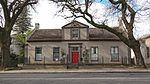 A rectangular house, 2 rooms deep, but with a roof of only 7 m span. The end-gables have been clipped, but the square and pedimented front gable, dated 1854, is an excellent example of its type; the 8-panelled door and the sashes date from the same time. These properties form an integral part of the historical and architectural nucleus of Paarl. The houses on these erven, the majority of which date from the nineteenth century are representative of the Cape Dutch, Georgian. Victorian and Edwardian styles