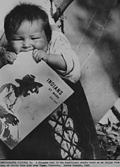 Ojibwe baby waits on a cradleboard while parents tend wild rice crops (Minnesota, 1940). 1940 govt photo minnesota farming scene chippewa baby teething on magazine indians at work.jpg