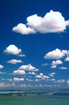 Chmury kłębiaste gatunku 'pięknej pogody' (Cumulus humilis), a nad horyzontem – chmury kłębiaste wypiętrzone (Cumulus congestus)