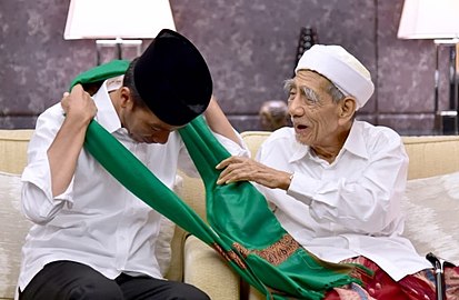 Presiden Joko Widodo saat dikalungi dengan sarung oleh Maimun Zubair, 2019.